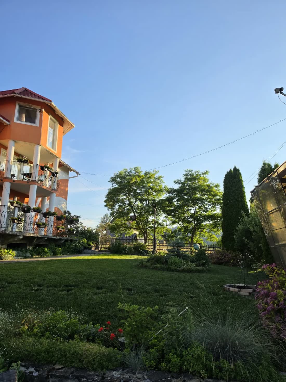 Casa Teo vara, cu balcoane înflorite și grădina